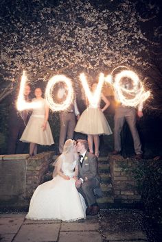 the bride and groom pose with their sparklers in front of them as they kiss