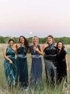 a group of women standing next to each other in tall grass