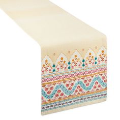 a white table runner with colorful designs on the edges and an orange, pink, blue, yellow and green border