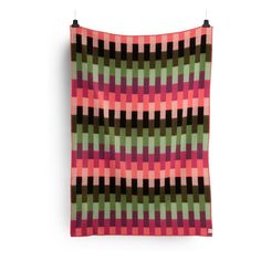 a pink, green and black blanket on a white background