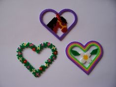 three pieces of beaded art are arranged in the shape of heart, flower and bird