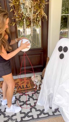 a woman standing next to a fake ghost