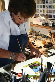 a woman in an art studio working on some artwork