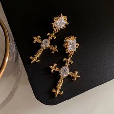 Make a statement with these intricate gold cross earrings accented by eye-catching crystals Material: Copper-Plated Gold and Cubic Zirconia Ear Pin: 925SILVER Weight: 12.7g/piece Size: L6.5cm * W3.3cm Gold Cross Earrings, Cross Earring, Ear Pin, Ear Pins, Cross Earrings, Gold Cross, Copper Plated, Effortless Chic, Modern Woman