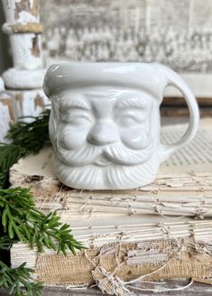 a white ceramic mug with a face on it