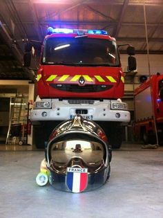 a red truck parked in a garage next to a helmet