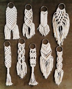 six white macrame key chains with tassels