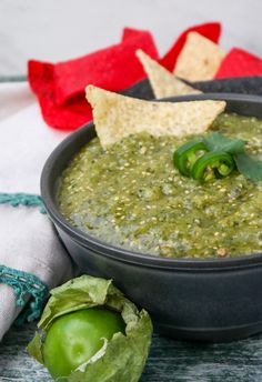 a black bowl filled with guacamole and tortilla chips