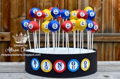 a cake topper made to look like billiards balls and numbers on sticks