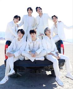 a group of men in white suits sitting on the back of a pick up truck