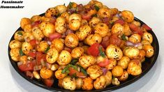 a black bowl filled with cooked food on top of a white table