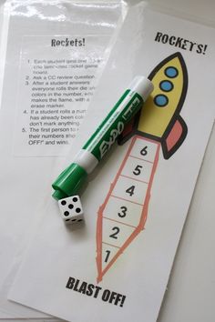 a green pen sitting on top of a piece of paper next to some dices