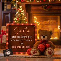 a teddy bear sitting next to a sign that says santa isn't the only one coming to town