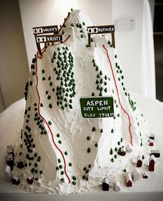 a cake made to look like a mountain with trees on top and signs above it