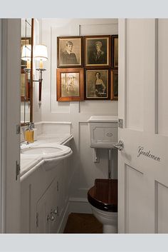 a bathroom with pictures on the wall and a toilet next to it's door