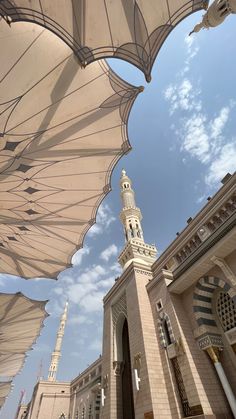 an outdoor area with many umbrellas and some buildings in the backgrouf