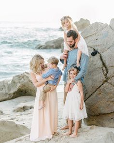 a family poses on the beach for a photo