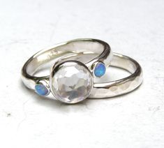 two silver rings with opal stones on them