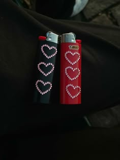 two lighters with hearts on them are sitting next to each other in someone's lap