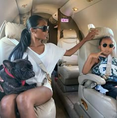 two women sitting in the back of an airplane with a dog