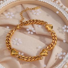 Classic never goes out of style and this one has hearts with a north star design giving you ultra feminine vibes. The Sammi Cuban Bracelet is definitely a must have in your jewelry collection. It can be worn alone or layered with our other gold bracelets. Dress it up or down either way its a stunner.*Shop the Sammi Necklace for a matching set! Gold: 18k gold platingMaterial: Stainless steelLength: 17cmWidth: 5mmWeight: 16g Waterproof jewelry Glazd Pouch with every order Free US shipping Easy Exc Trendy Metal Heart Bangle Bracelet, Trendy Gold Heart Bracelet With Adjustable Chain, Trendy Gold Stainless Steel Charm Bracelet, Gold Heart-shaped Stainless Steel Bracelet, Gold Metal Chain Bracelet For Valentine's Day, Gold Metal Bracelets For Valentine's Day, Trendy Rose Gold Heart Bracelet, Gold Stainless Steel Bracelets For Valentine's Day, Trendy Gold Heart Bracelet As Gift