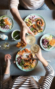 two people sitting at a table with plates of food and drinks in front of them