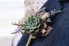 a boutonniere with succulents and flowers on it