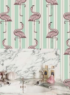 pink flamingos are lined up on the wall in this bathroom with marble counter tops