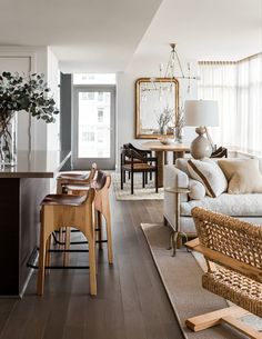 a living room filled with furniture next to a kitchen and dining room table on top of a hard wood floor