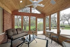 a living room filled with furniture and windows covered in wood planks on top of a hard wood floor