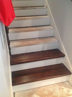 a set of stairs with wooden treads and white painted handrails in a home