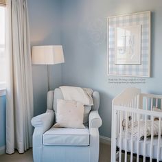 a baby's room with blue walls and white furniture