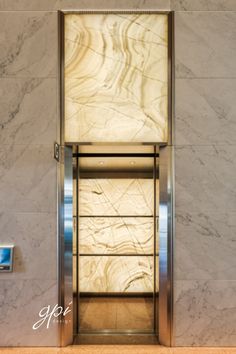 an elevator with marble walls and doors