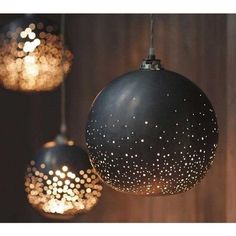 three black and white lights hanging from a wooden ceiling with stars on the light bulbs