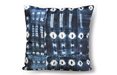 a black and white pillow with an abstract design on the front, sitting against a white background