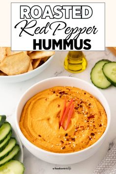 roasted red pepper hummus in a white bowl surrounded by cucumbers