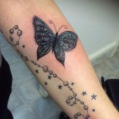 a woman's arm with a butterfly and stars tattoo on the left side of her leg