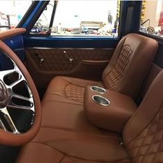 the interior of an old car with brown leather seats and steering wheel, including center console