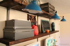 a shelf with some items on it and two lights hanging from the ceiling above them