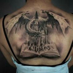 the back of a woman's shoulder with an open book and wings on it