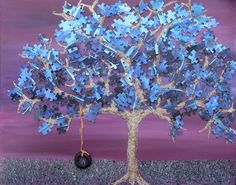 a painting of a tree with blue puzzle pieces on it