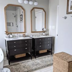 a bathroom with two sinks, mirrors and a rug on the floor in front of it