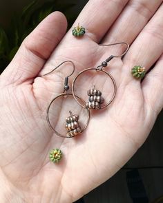 "Pumpkin Stack Hoop Earrings , Botanical Pokeweed Jewelry, Real Plant Earrings, Fall Halloween Jewelry ------------------------------ :: D E T A I L S :: This listing is for a pair of dainty copper pumpkin hoop earrings, perfect for bringing a hint of fall to your wardrobe! These earrings are made from berries from the Pokeweed plant which look like mini pumpkins. Each pair of earrings is unique, as each one contains  REAL berries that I responsibly foraged that is encased in copper. ------------------------------ :: M E A S U R E M E N T S :: -These stacked pumpkin earrings come on nickel free ear wires The pumpkins on each necklace are a bit more than 1/4\" wide. ------------------------------- . . . . . Want to see more of what's available in my shop? Click here: GratefullyDreaming.etsy Pokeweed Plant, Copper Pumpkins, Pumpkin Stack, Pumpkin Jewelry, Plant Earrings, How To Wear Rings, Mushroom Jewelry, Blue Sapphire Necklace, Earrings Fall