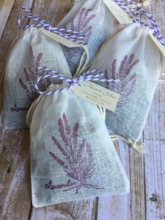 three bags with lavender flowers on them sitting on a wooden floor next to twine string