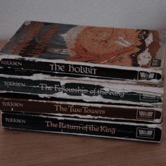 a stack of books sitting on top of a wooden table