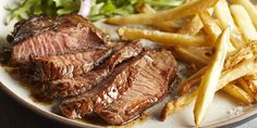 a plate with steak, french fries and lettuce