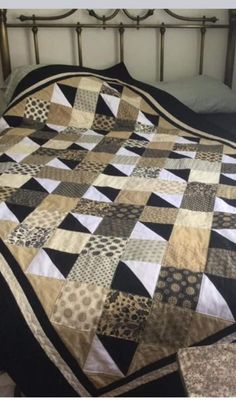 a bed with a black and white quilt on it