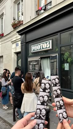 two people holding up their cell phones in front of a store