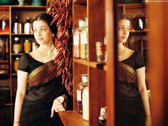 a woman standing in front of a wooden cabinet