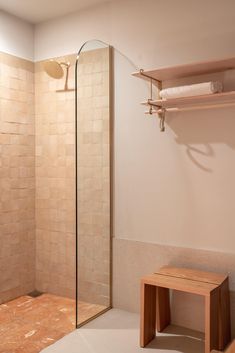 a walk in shower sitting next to a wooden bench